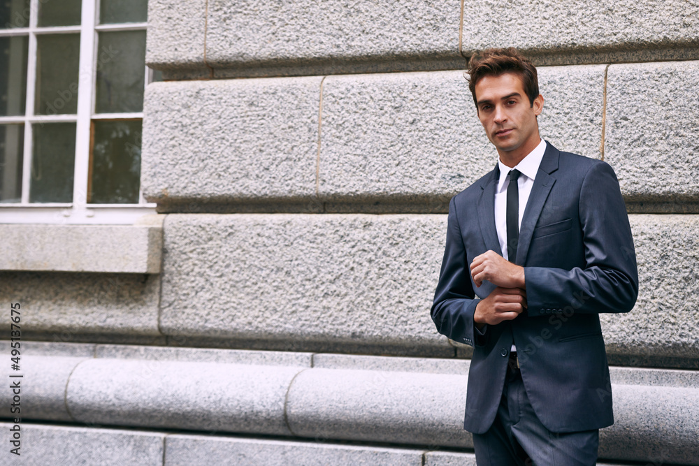 The lifestyle of a businessman. Portrait of a handsome businessman in a suit standing outside a city building. The lifestyle of a businessman. Portrait of a handsome businessman in a suit standing outside a city building.
