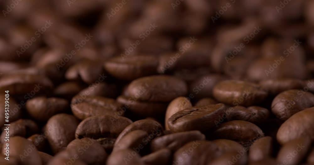 Slow motion close-up of whole roasted coffee beans. Rotation and fall сoffee beans Slow motion close-up of whole roasted coffee beans. Rotation and fall сoffee beans