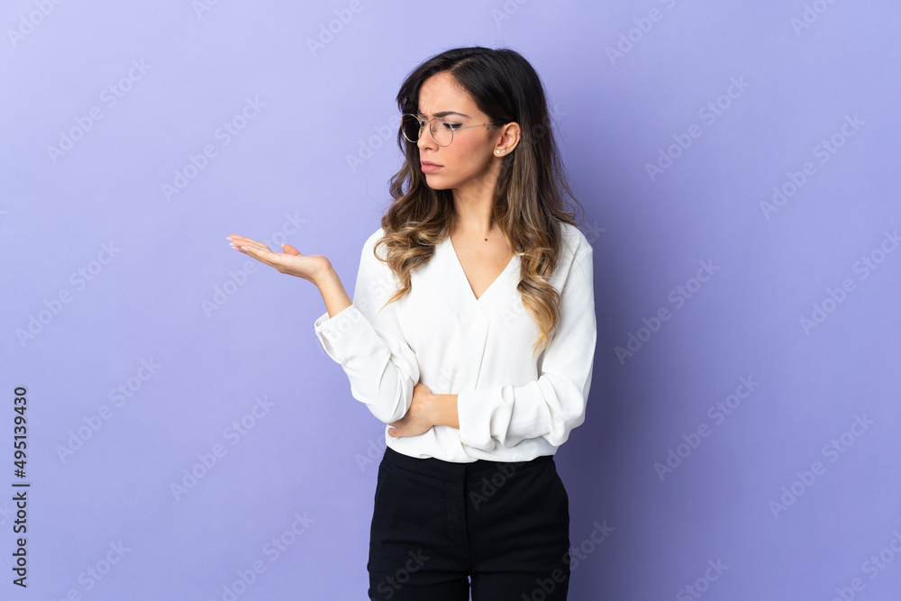 Young caucasian woman isolated on purple background holding copyspace with doubts Young caucasian woman isolated on purple background holding copyspace with doubts