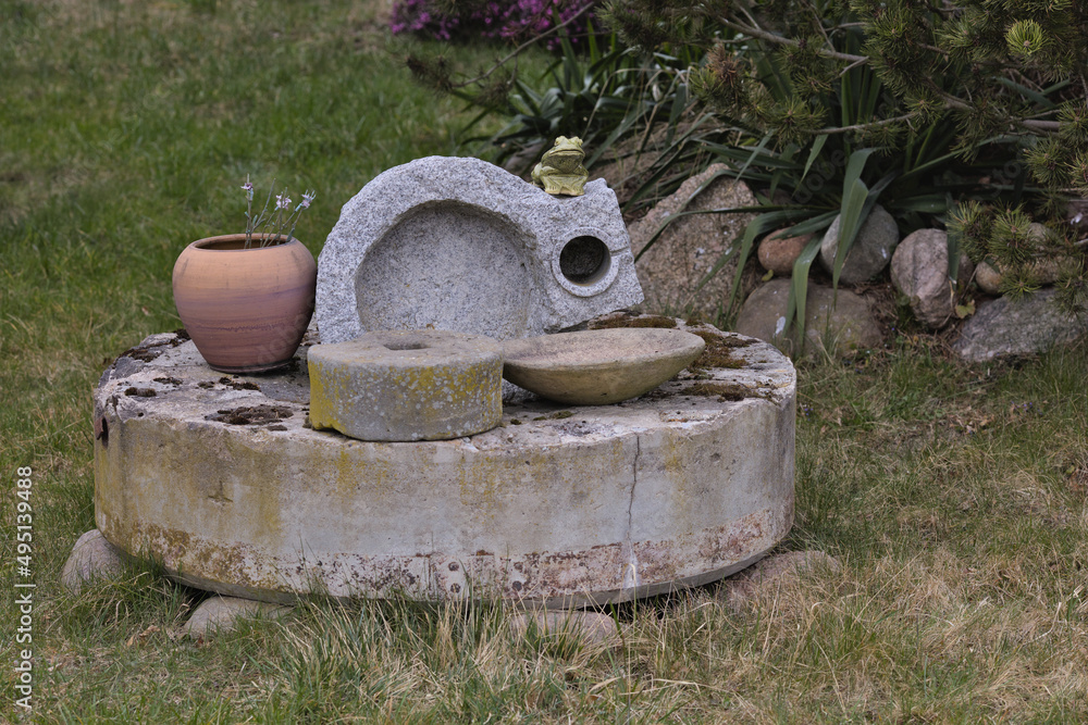 Obraz premium Vintage grain mill used as a garden decoration