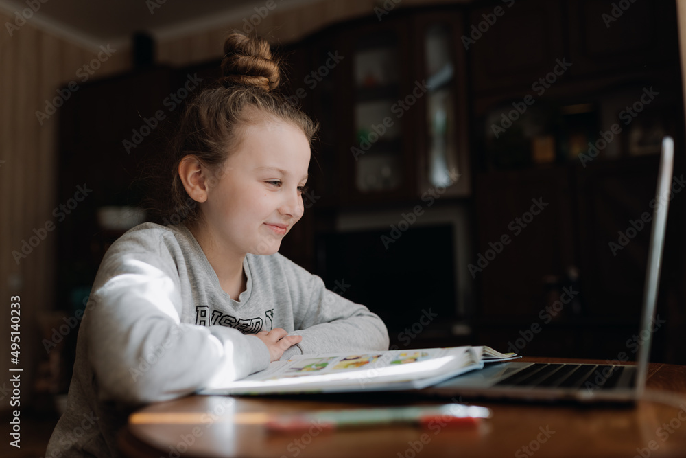 Cute girl with pc and book indoors. Education, technology and children concept Cute girl with pc and book indoors. Education, technology and children concept