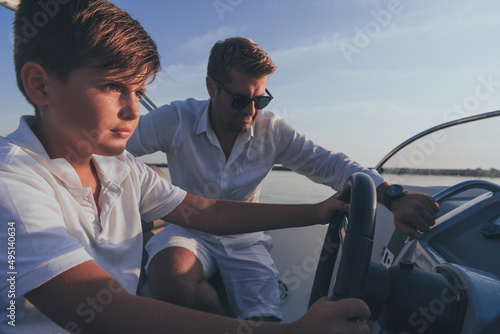Father and son enjoy their vacation together while riding a luxury boat at sea. Selective focus 