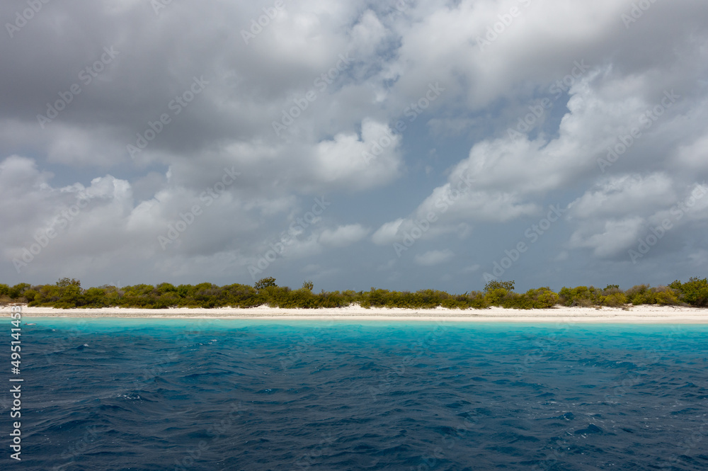 Looking at the sandy shoreline of the deserted island of Klein Bonaire from the turquoise water