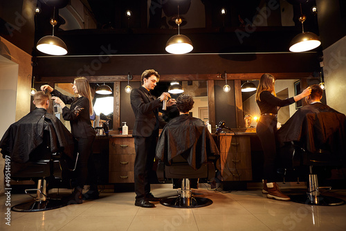Salon. Man in a barber chair. The hairdresser serves the client in the barbershop. The concept of male cosmetology.