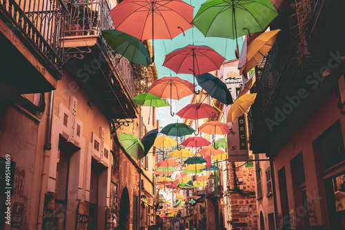 Colorful umbrella on the narrow street © Domonkos
