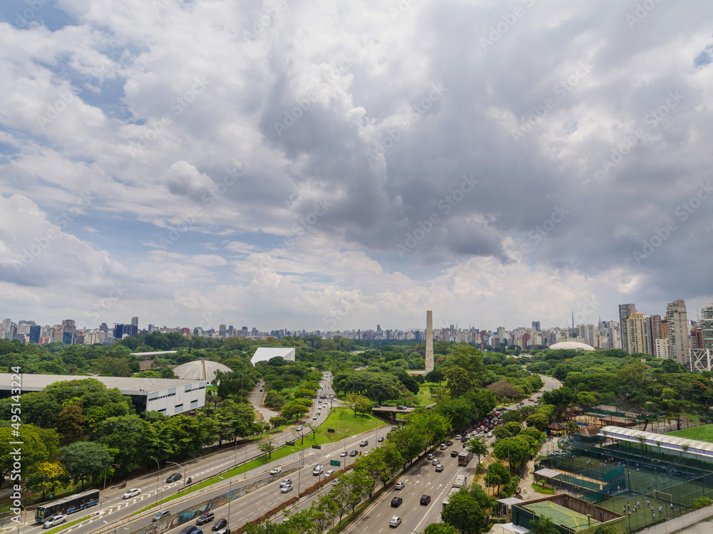 Fototapeta premium Vista aérea da zona sul de São Paulo, com Ibirapuera, avenidas e skyline da cidade, céu parcialmente nublado.