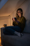 Woman holding credit card and using smartphone while online shopping at home
