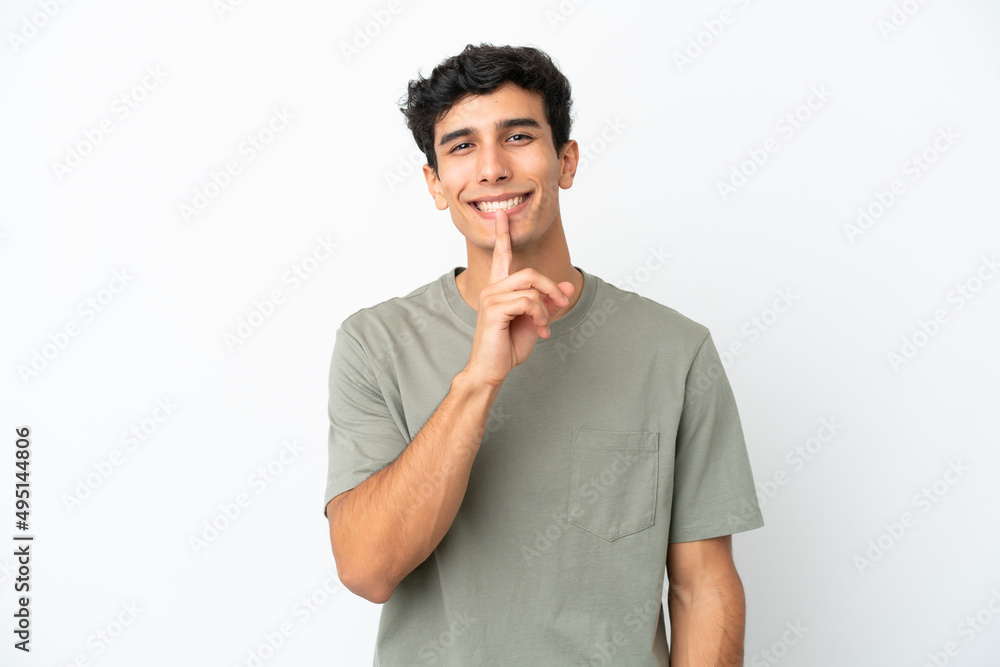 Young Argentinian man isolated on white background showing a sign of silence gesture putting finger in mouth Young Argentinian man isolated on white background showing a sign of silence gesture putting finger in mouth