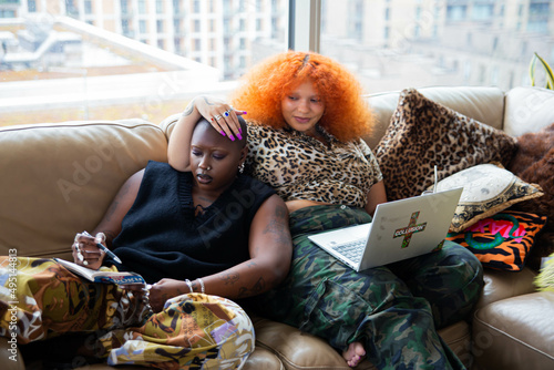 Black lesbian couple relaxing in living room.