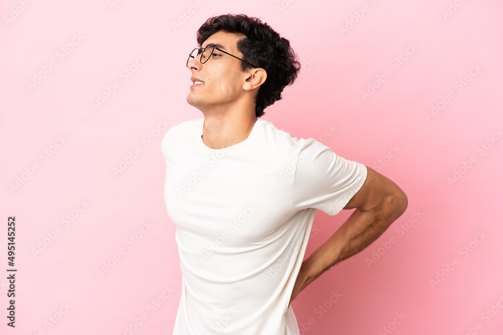 Young Argentinian man isolated on pink background suffering from backache for having made an effort Young Argentinian man isolated on pink background suffering from backache for having made an effort