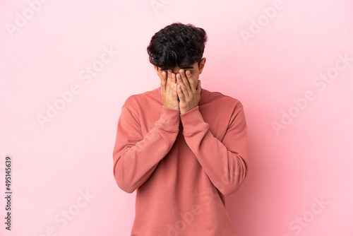 Young Argentinian man isolated on pink background with tired and sick expression © luismolinero