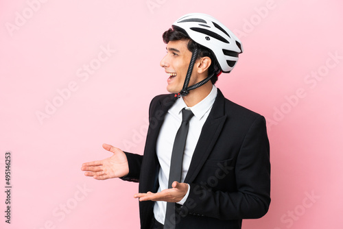 Argentinian businessman with bike helmen isoleted on pink background photo