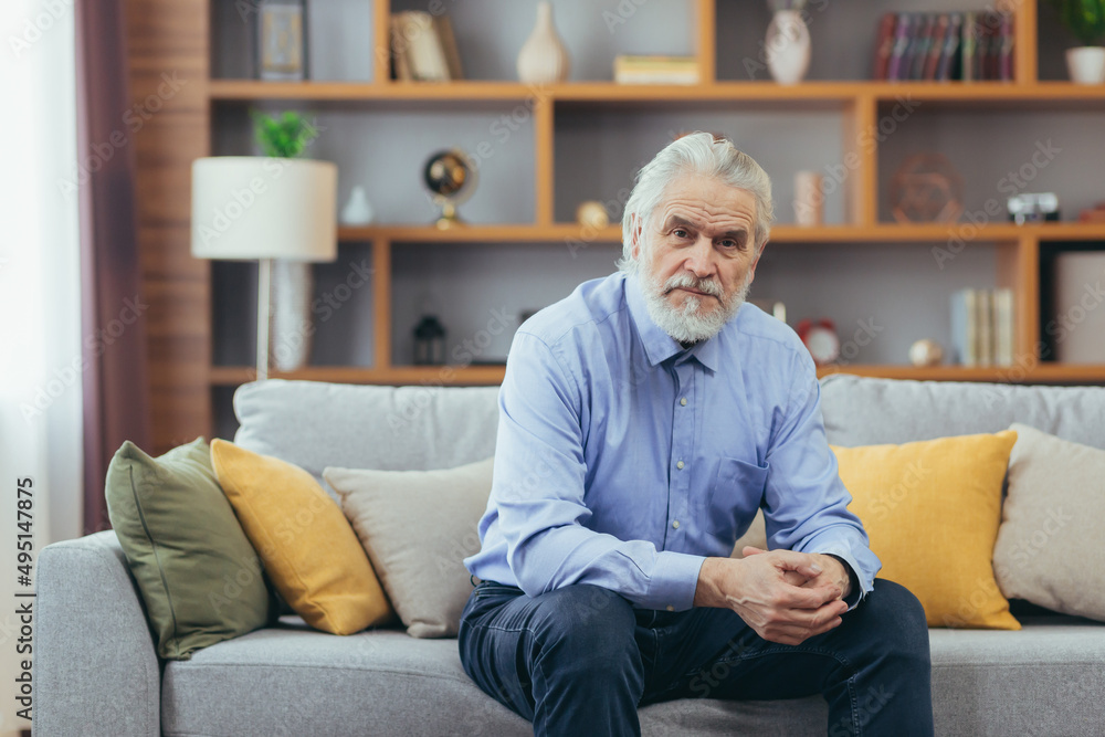 Serious for pensive grandfather man sitting on sofa at home Serious for pensive grandfather man sitting on sofa at home