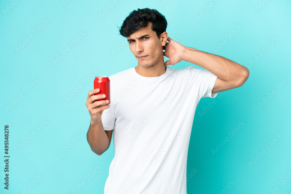 Young Argentinian man holding a refreshment isolated on blue background having doubts Young Argentinian man holding a refreshment isolated on blue background having doubts