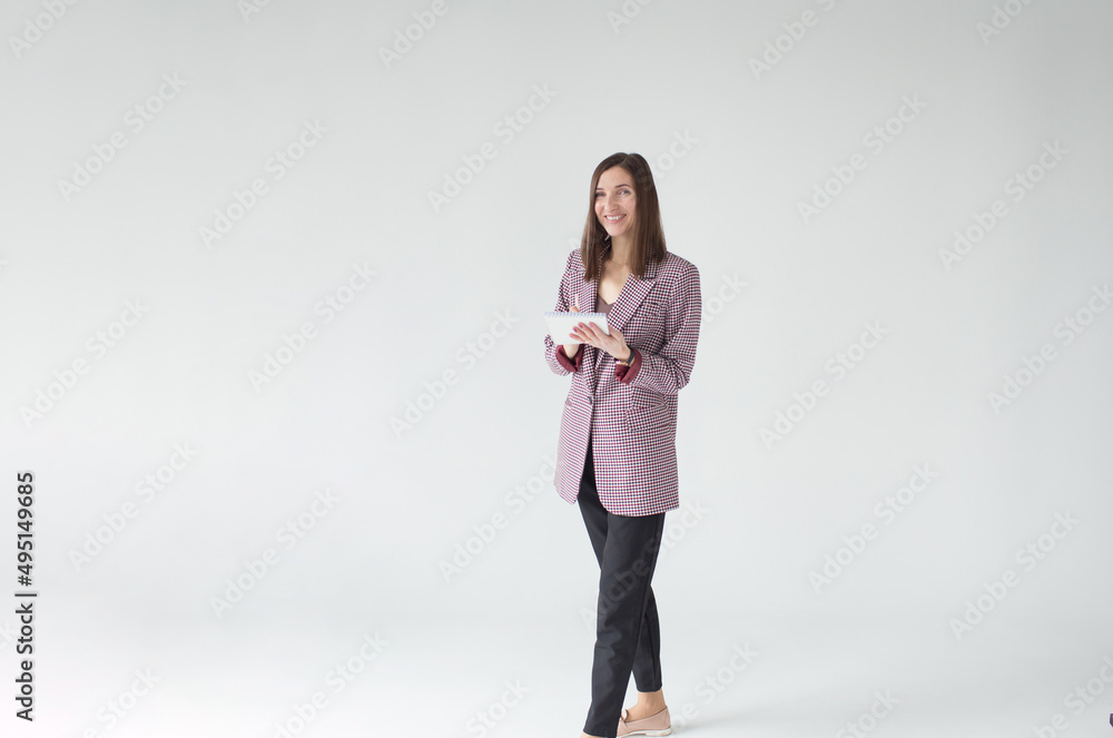 Portrait of a smiling business woman in a formal suit with a notebook in her hands on an isolated white background Portrait of a smiling business woman in a formal suit with a notebook in her hands on an isolated white background