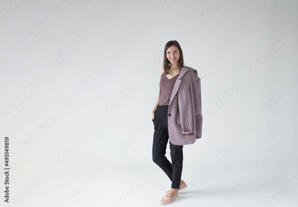a beautiful woman with a jacket over her shoulder. Full-length portrait isolated on a white studio background. a beautiful woman with a jacket over her shoulder. Full-length portrait isolated on a white studio background.