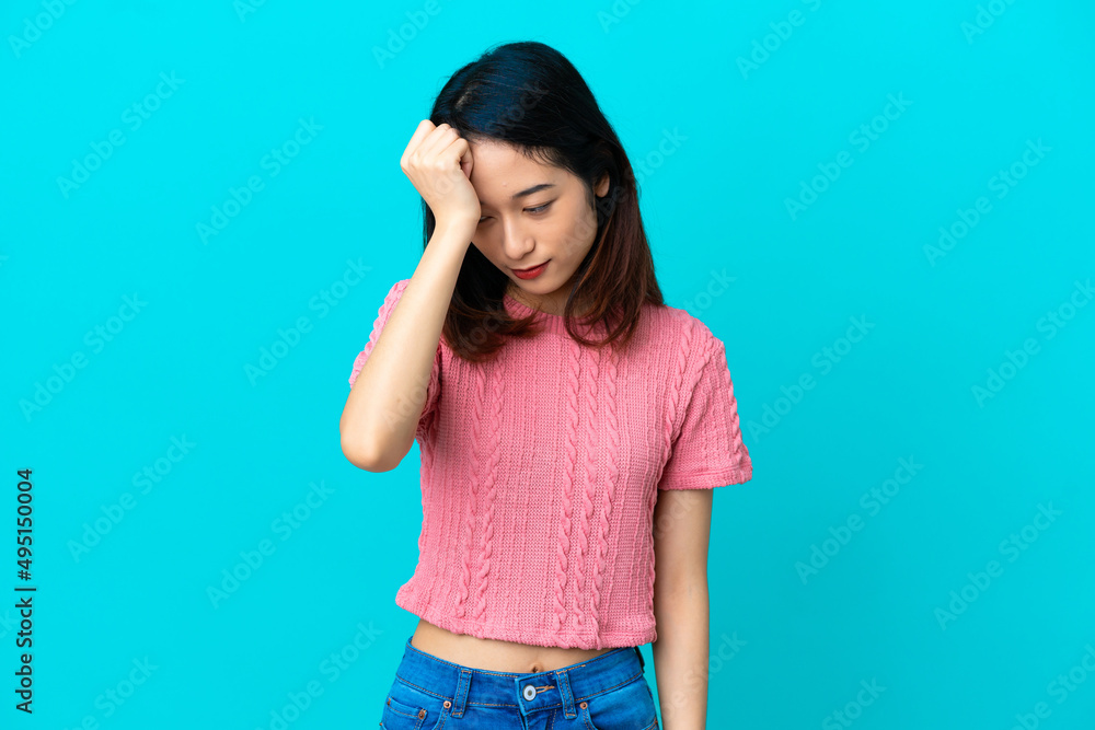 Young Vietnamese woman isolated on blue background with headache Young Vietnamese woman isolated on blue background with headache