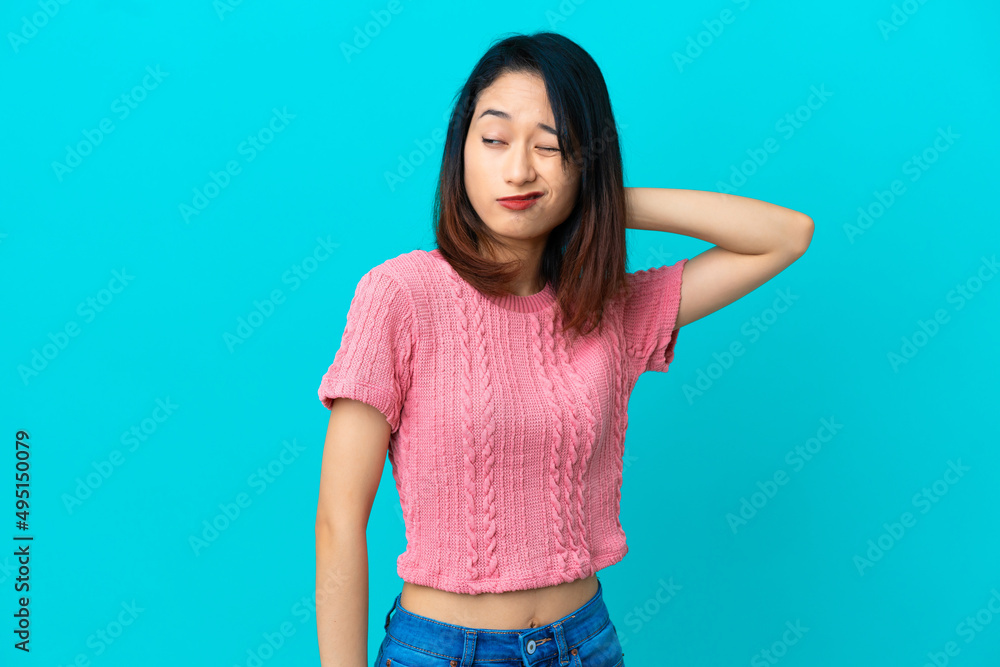 Young Vietnamese woman isolated on blue background with neckache Young Vietnamese woman isolated on blue background with neckache