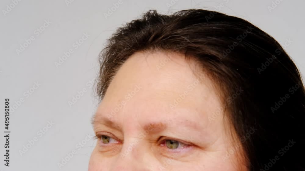 close-up of mature charismatic woman 50 years looks at the camera, eyes and forehead, small wrinkles on the face, overhang, the concept of cosmetic anti-aging procedures, facial massage close-up of mature charismatic woman 50 years looks at the camera, eyes and forehead, small wrinkles on the face, overhang, the concept of cosmetic anti-aging procedures, facial massage