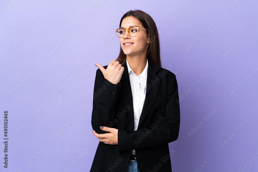 Business woman isolated on purple background pointing to the side to present a product Business woman isolated on purple background pointing to the side to present a product