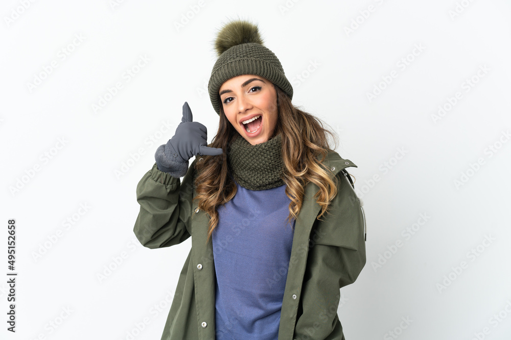 Young girl with winter hat isolated on white background making phone gesture. Call me back sign Young girl with winter hat isolated on white background making phone gesture. Call me back sign