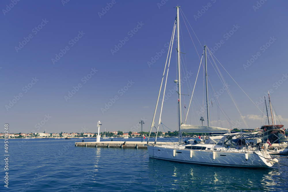 A photograph of a ship and a luxury yacht anchored in port. Beautiful photo of a Mediterranean port