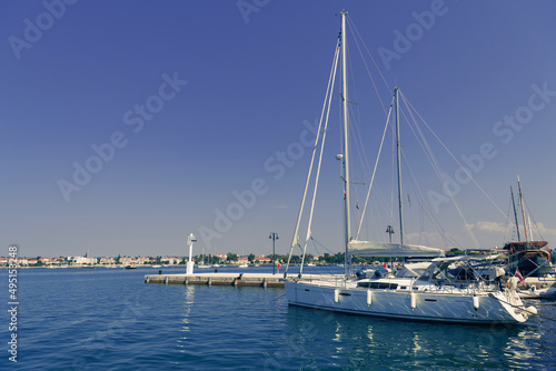 A photograph of a ship and a luxury yacht anchored in port. Beautiful photo of a Mediterranean port