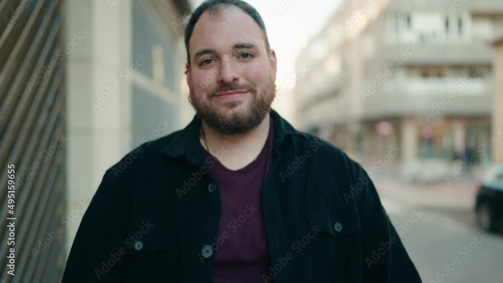 Young plus size man smiling confident standing with arms crossed gesture at street Young plus size man smiling confident standing with arms crossed gesture at street