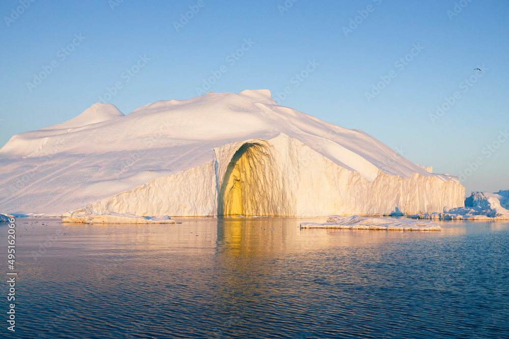 Big icebergs floating over sea at sunset