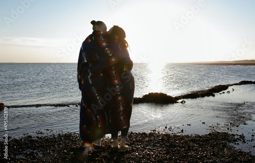 lesbian couple at the beach wrapped in native American blanket