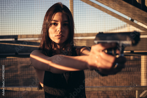 a woman with a weapon is training to shoot photo