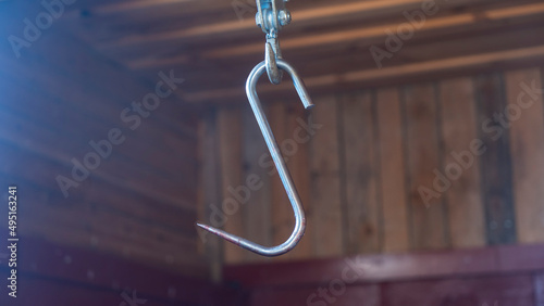 A hook for cutting animal carcasses in a village barn. Butchered and processed hunting trophy hanging in a slaughter house.