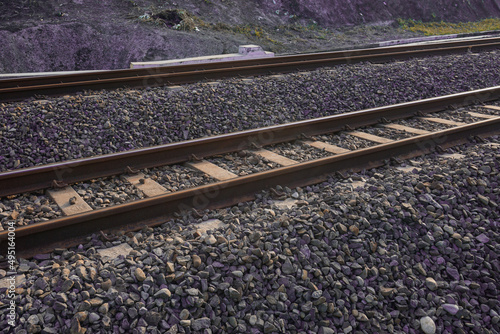 The railroad tracks pass through the grooved bearings buried under the shards of cobblestone