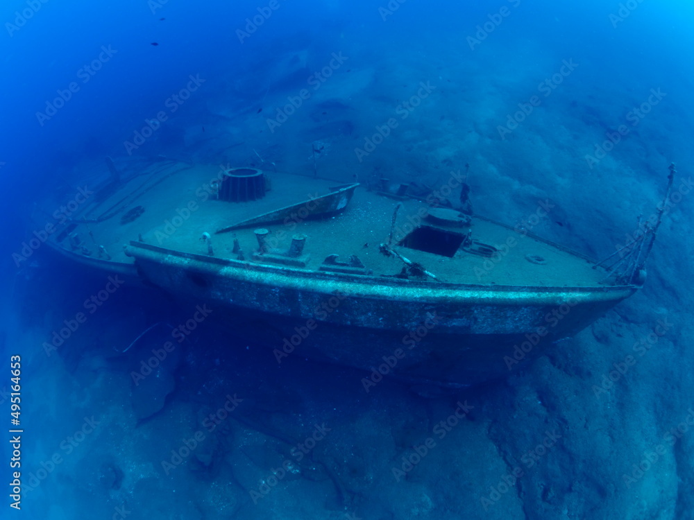 Naklejka premium scuba divers exploring shipwreck scenery underwater ship wreck deep blue water ocean scenery of metal underwater
