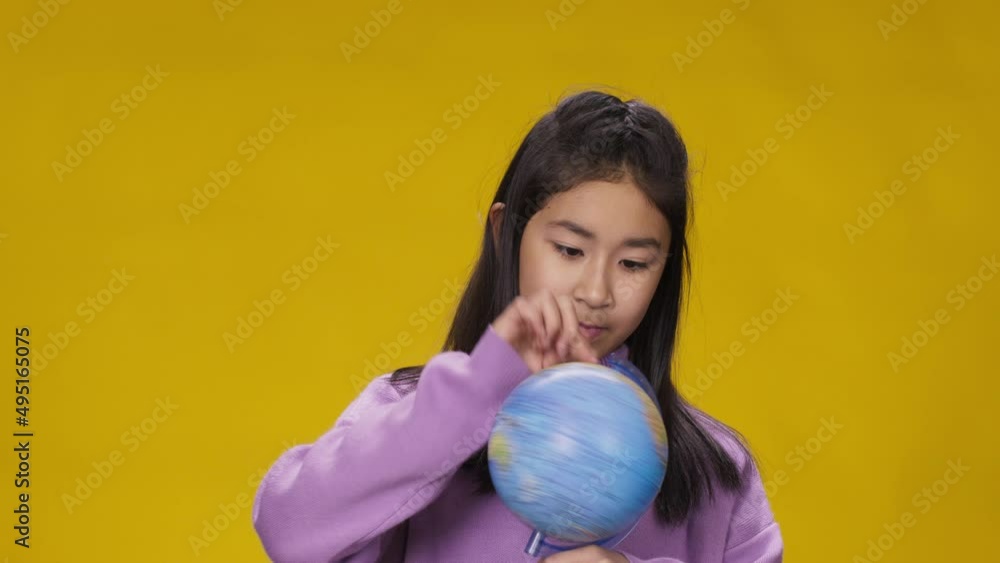 asian girl spin globe chooses country and happily says yes asian girl spin globe chooses country and happily says yes