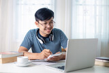 A young Asian man video conference with a computer teacher in his home / concept E-learning, online education and internet social distancing protect from COVID-19 viruses.