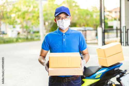 Deliveryman of goods and parcels to customers by protecting them with medical masks and gloves / Online shopping order under quarantine coronavirus covid-19