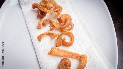 Crispy pork skin lies on a paper towel. 
 photo