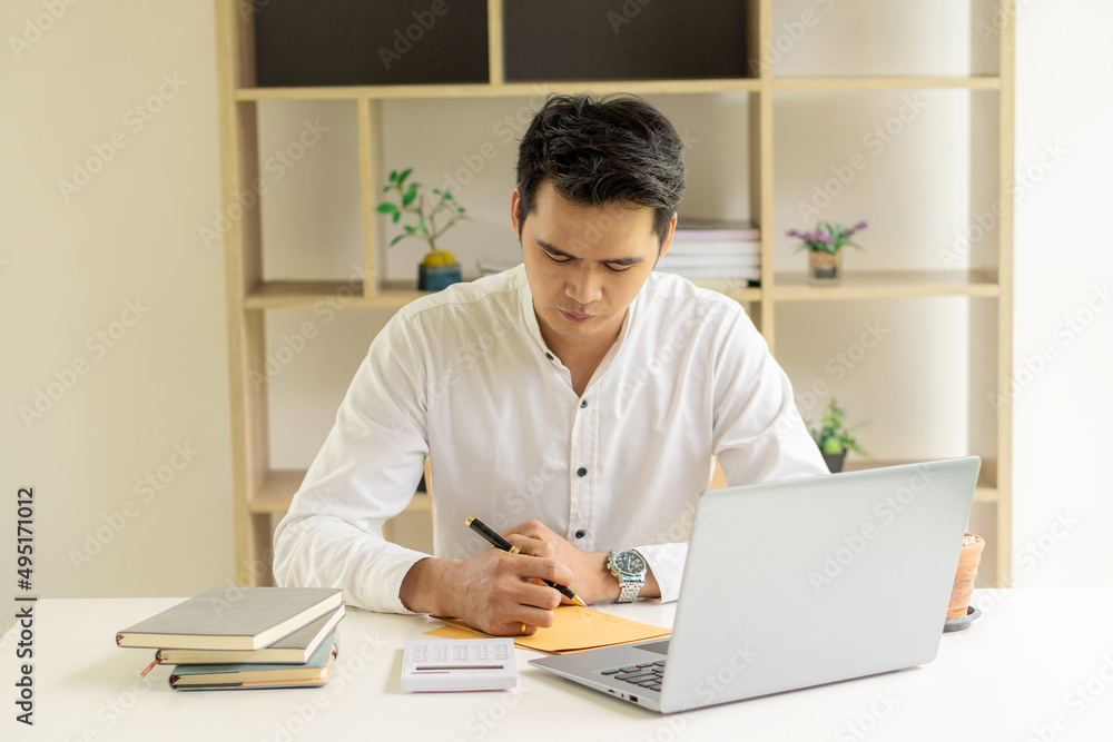 Young Asian businessman working on laptop in concept office working online. Freelance business.