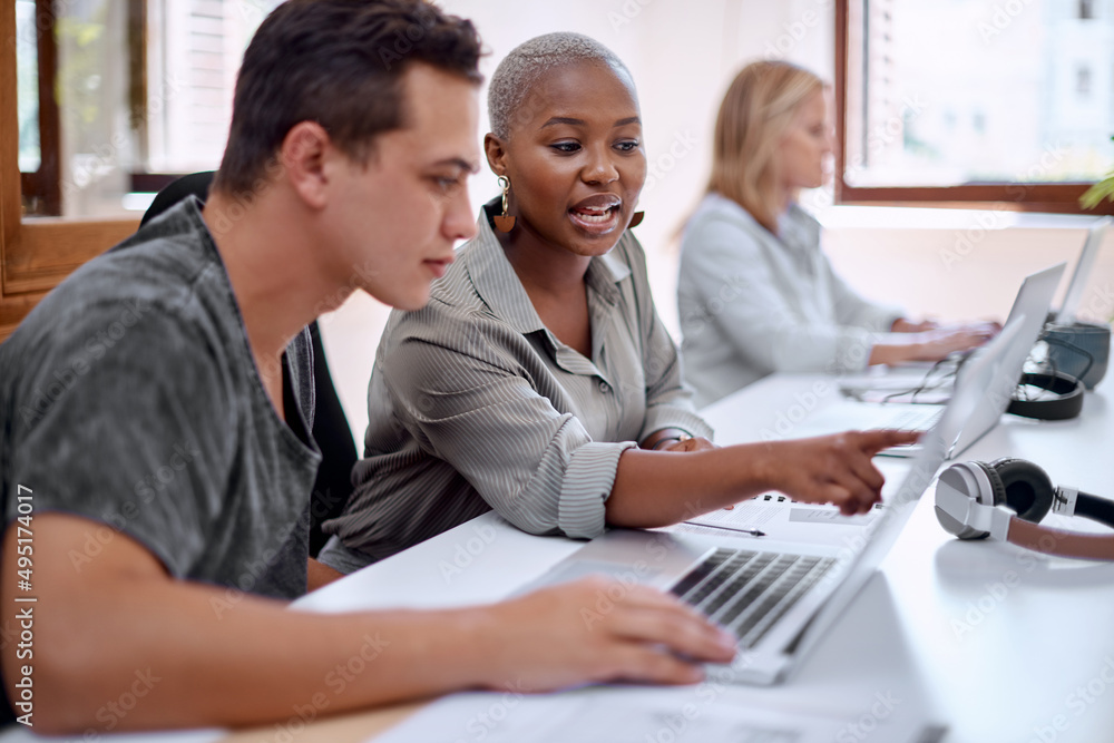 Uniting on a creative project. Shot of two businesspeople working together on a laptop in an office. Uniting on a creative project. Shot of two businesspeople working together on a laptop in an office.