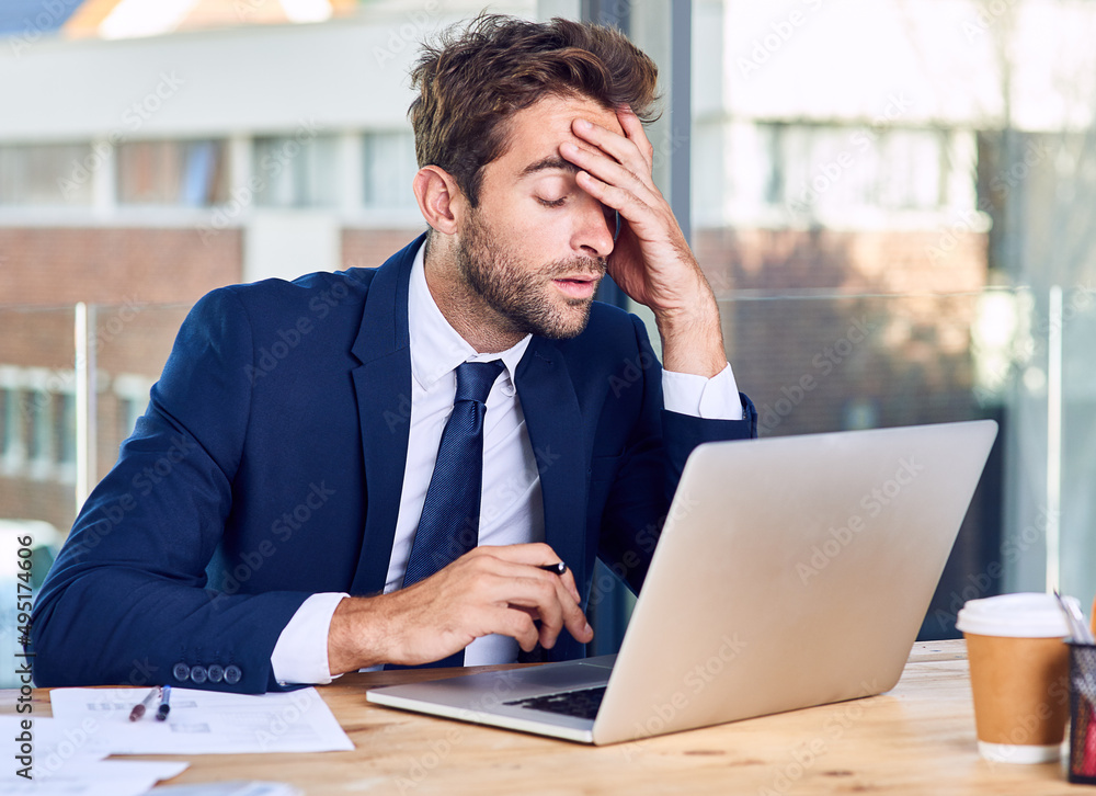 Im calling it a day. Shot of a businessman looking exhausted while working on his laptop. Im calling it a day. Shot of a businessman looking exhausted while working on his laptop.