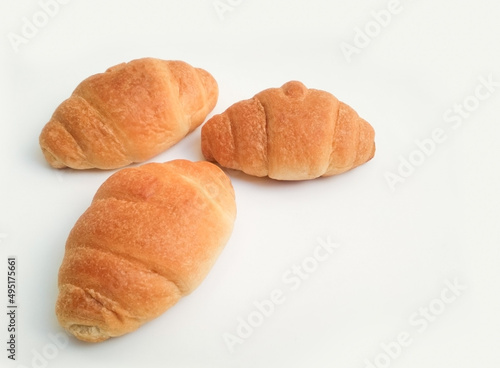Three freshly baked croissants on a white background, with copy space photo