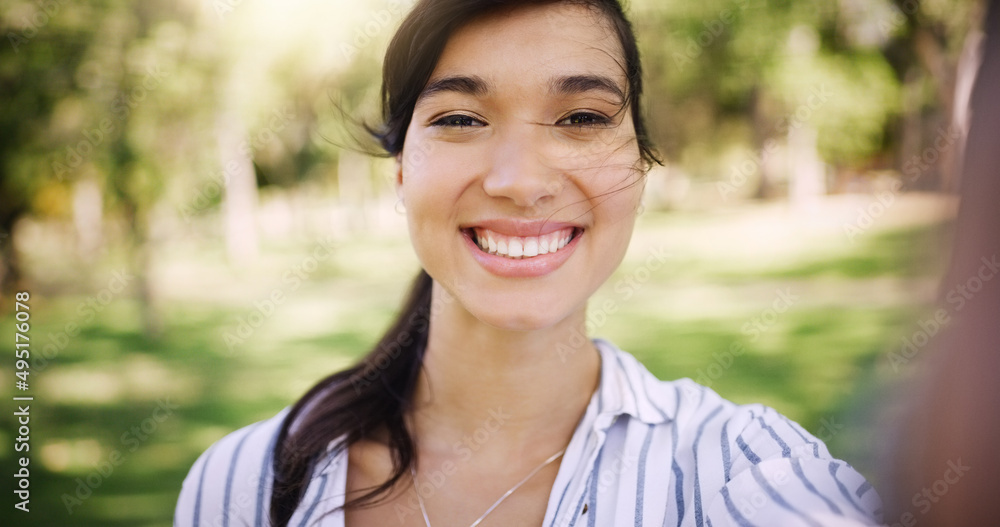 Her smile brightens up any day. Portrait of an attractive young woman taking a selfie while relaxing outdoors. Her smile brightens up any day. Portrait of an attractive young woman taking a selfie while relaxing outdoors.