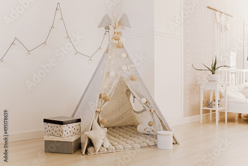Children's wigwam with toys in the New Year's interior © Антон Романюк