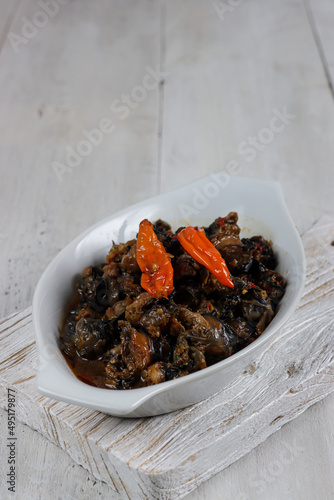 Krengsengan keong or Tumis keong is stir fry snail meat with spicy chili sauce photo