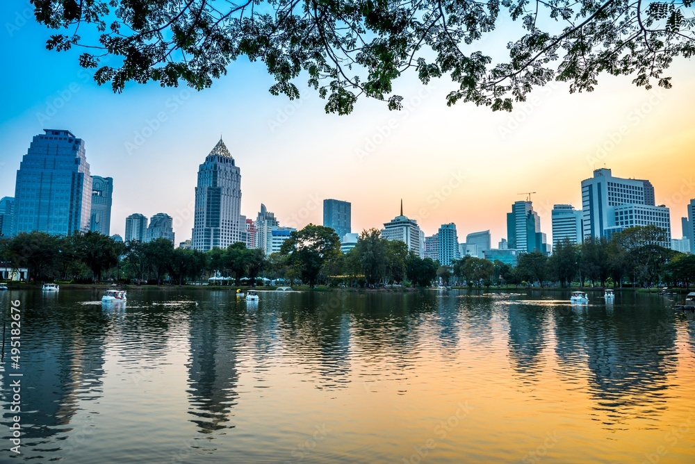 Fototapeta premium Lumphini park in Bangkok Thailand city twilight evening. Green park in city, cityscape concept.