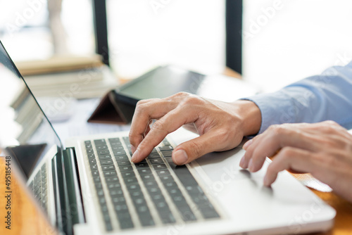 Business analyst concept the hands of businessman inserting the information of the products by using laptop
