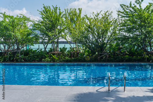 Photography Outdoor rooftop swimming pool with green tree garden in sunny day