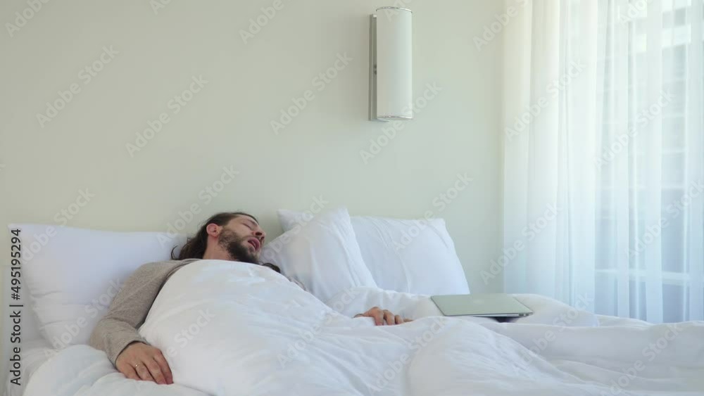 Wake up and check your laptop mail. Caucasian man works out in bed. Get sick and work in hotel. Home white room freelancers. Happy morning. Scroll news. Online call family. people far away Wake up and check your laptop mail. Caucasian man works out in bed. Get sick and work in hotel. Home white room freelancers. Happy morning. Scroll news. Online call family. people far away