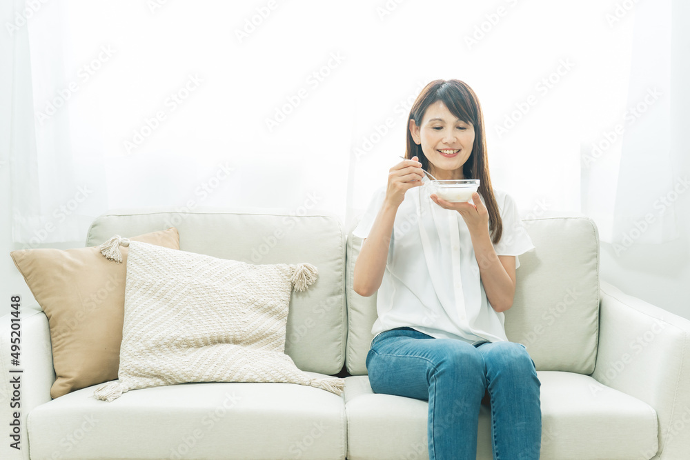ソファでヨーグルトを食べる女性(笑顔)
ソファでヨーグルトを食べる女性(笑顔)